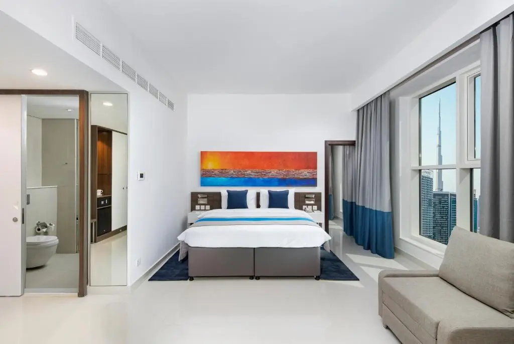 اتاق خواب Executive Suite در هتل Citymax Hotel Business Bay با تخت دو نفره و نمای برج خلیفه از پنجره.