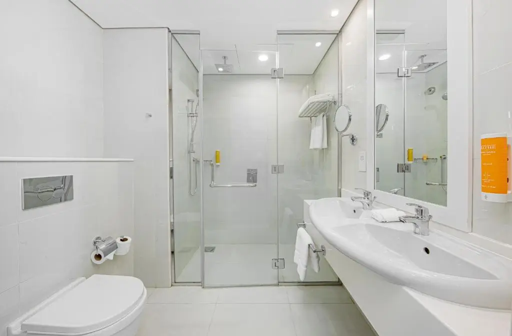 نمای مدرن و روشن از سرویس بهداشتی اتاق Executive Suite در هتل Citymax Hotel Business Bay، با طراحی مینیمال و دوش شیشه‌ای